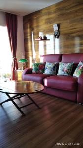 a living room with a purple couch and a coffee table at Appartement cosy les pieds dans l’eau, vue mer exceptionnelle in Crozon