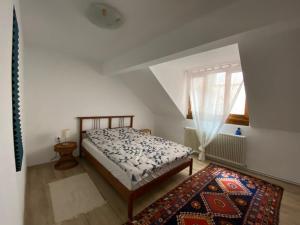 um quarto com uma cama, um tapete e uma janela em Rebreanu Suite em Sibiu