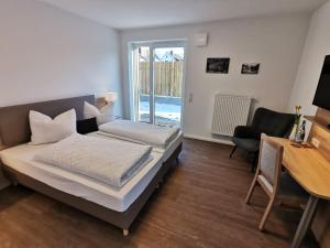 a bedroom with a bed and a desk and a desk at Hotel zur Erholung in Buxtehude