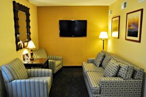 Camera d'albergo con 2 divani e TV a schermo piatto di Candlewood Suites Raleigh Crabtree by IHG a Raleigh