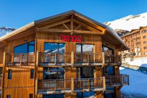 ein Gebäude mit einem Schild, das oben steht in der Unterkunft Langley Hôtel Tango in Val Thorens