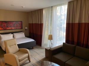 ベイルートにあるStaybridge Suites Beirut, an IHG Hotelのベッドとソファ付きのホテルルーム