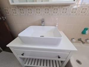 y baño con lavabo blanco y bañera. en Digby's Place - waterfront apartment, en The Entrance