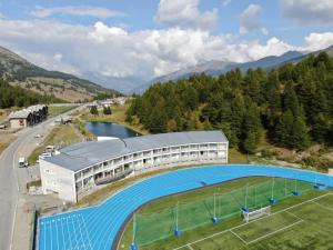 a building with a tennis court next to a river at Hotel Lago Losetta in Sestriere