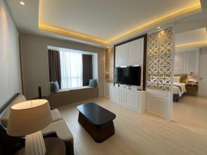 a large living room with a couch and a television at Sutasoma Hotel in Jakarta