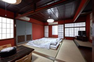 1 dormitorio con 1 cama en una habitación con paredes rojas en Ryokan Yamamuro, en Kanazawa