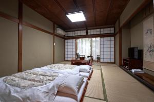 Habitación con 2 camas y TV. en Ryokan Yamamuro, en Kanazawa