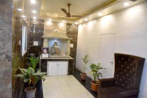 a living room with a chair and plants at Hotel Parag in Pune