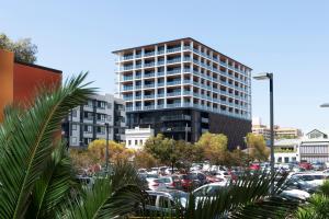 un edificio alto con coches estacionados en un estacionamiento en R Hotel Geelong, en Geelong