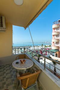 a balcony with a table and chairs and a view of the beach at Comfortable apartment next to the beach in Durrës