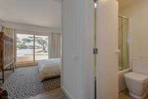 - une chambre avec un lit et une salle de bains avec des toilettes dans l'établissement M&M Home, à Quinta do Lago