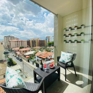 a balcony with a table and chairs and a view of a city at Hotel Catena in Cochabamba