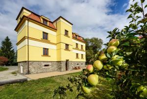 een geel gebouw met een appelboom ervoor bij Apartmány Na Seníku in Třeboň