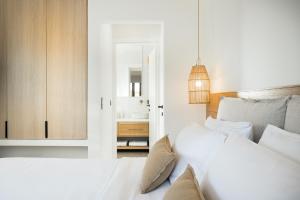 a white bedroom with a bed and a bathroom at OD Luxury Villa in Pylos