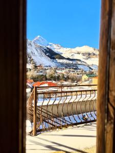 un pont en bois avec une montagne enneigée en arrière-plan dans l'établissement Sunny Mountain House, à Kazbegi