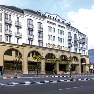 un grande edificio bianco sul lato di una strada di Hotel Des Indes Menteng a Giacarta