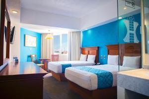 twee bedden in een hotelkamer met blauwe muren bij Hotel Lois Veracruz in Veracruz