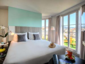 um quarto com uma cama grande e uma janela grande em Ibis Styles Nice Centre Gare em Nice