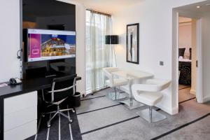 a room with a table and chairs and a tv at Crowne Plaza Manchester City Centre, an IHG Hotel in Manchester