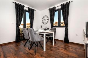 jadalnia ze stołem, krzesłami i zegarem w obiekcie Deluxe Apartments A&A w Rovinj