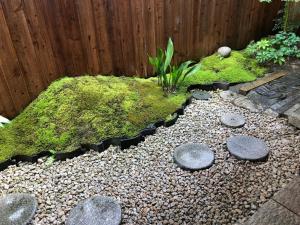 einen Garten mit Felsen und Moos und einem Zaun in der Unterkunft Kyoto style small inn Iru in Kyoto