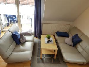 Sala de estar con 2 sofás y mesa de centro en Ferienhaus Poseidon, en Neuharlingersiel