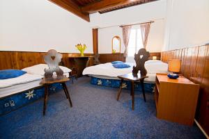 - une chambre avec 2 lits et 2 tables dans l'établissement Penzion Na Rychtě, à Malá Morávka