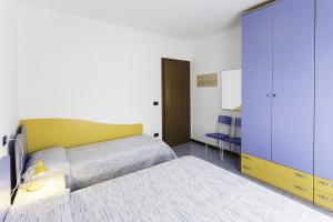 1 dormitorio con 1 cama grande y armario amarillo en TIGLI Lido Altanea, en Caorle