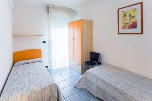 1 dormitorio con 2 camas individuales y ventana en TIGLI Lido Altanea, en Caorle