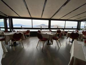 un ristorante con tavoli, sedie e ampie finestre di Hotel Concorde ad Arona