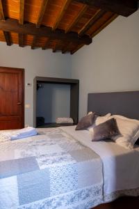 a large white bed in a room with wooden ceilings at Residenza Roma in Pistoia