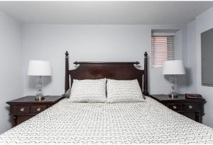 um quarto com uma cama com 2 mesas de cabeceira e 2 candeeiros em Forrestville Ave Large Suite em Chicago