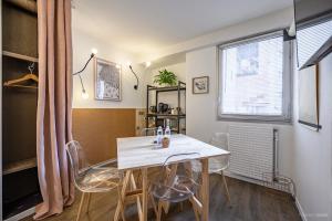 a dining room with a white table and chairs at Hotel Gascogne in Toulouse