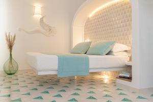 una camera con un letto con una grande testiera di Petrea Lifestyle Suites a Positano