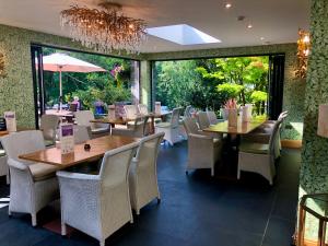 un restaurant avec des tables et des chaises et un lustre dans l'établissement The Mary Mount Hotel, à Keswick