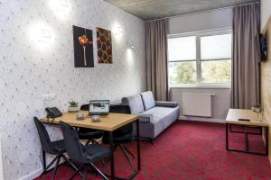 een woonkamer met een tafel en een bank bij Hotel 107 in Rumia