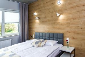 een slaapkamer met een groot bed en een houten muur bij Hotel 107 in Rumia