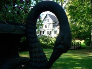 una estatua de un banco frente a una casa en Gutshaus Kubbelkow, en Bergen auf Rügen