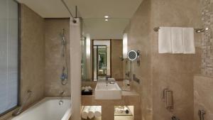 a bathroom with a tub and a sink and a shower at Holiday Inn Jaipur City Centre, an IHG Hotel in Jaipur