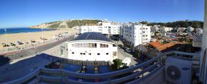 Blick auf eine Stadt mit Strand und Gebäuden in der Unterkunft Beachfront Apartment Nazaré in Nazaré