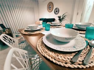 une table avec plaques et bols en dessus dans l'établissement Beachfront Apartment Nazaré, à Nazaré