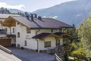 ein großes weißes Haus mit Bergen im Hintergrund in der Unterkunft Apartment Zell am Ziller 2 in Zell am Ziller