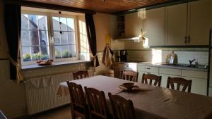 a kitchen with a table and chairs and a kitchen with a window at Gîte du Soleil in Anhée