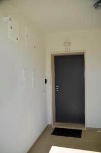 a hallway with a black door and a basketball hoop at Cazenn Nazaré - Apartment Z in Nazaré