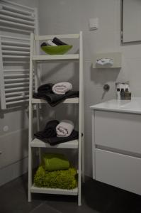 a bathroom with a shelf with towels and a sink at Cazenn Nazaré - Apartment Z in Nazaré