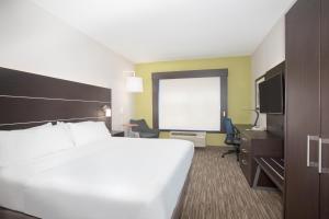 een hotelkamer met een groot wit bed en een bureau bij Holiday Inn Express Hotel & Suites Longmont, an IHG Hotel in Longmont