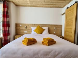 1 dormitorio con 1 cama con 2 toallas en Chalet Le Granitic, en Les Menuires