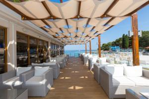 Blick auf den Strand von einem Restaurant mit weißen Stühlen in der Unterkunft Apartments Galijot Plava Laguna in Poreč