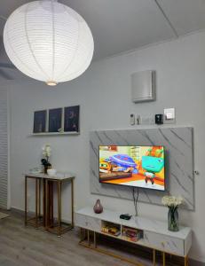 sala de estar con TV de pantalla plana en la pared en Maya Homestay Putrajaya @ Twelve, en Putrajaya