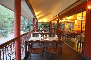 un ristorante con tavolo e sedie su un balcone di Outpost@Alibaug ad Alibaug